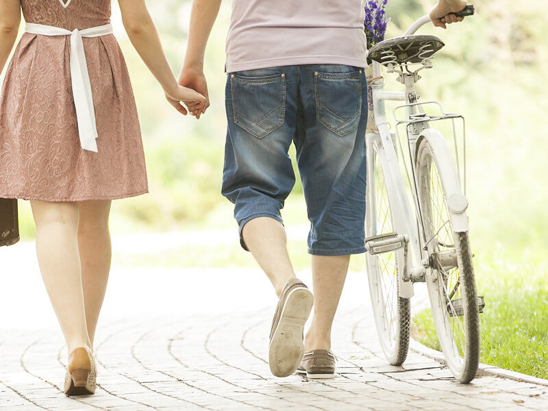 Couple walking with a white bicycle