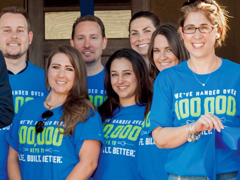 Coworkers pose for a photo with their Life Buildt Better t-shirts