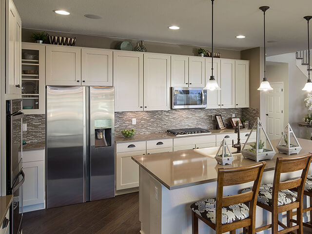 Kitchen with white cabinets, granite countertops and wooden chairs