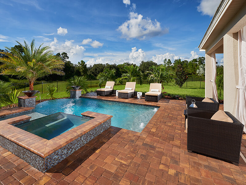 Brown stone pool area with jacuzzi