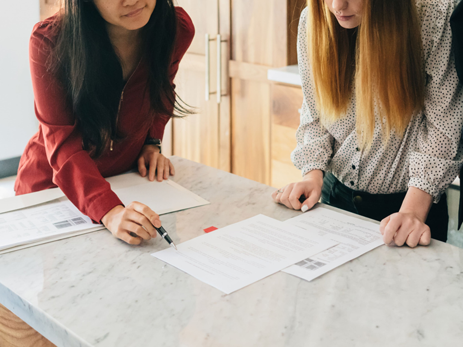 Two women discussing papers