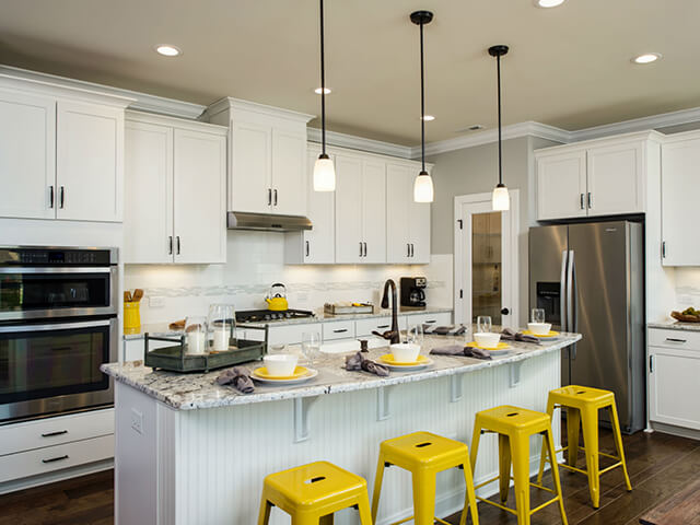Kitchen with white cabinets, granite countertops and yellow bar stools