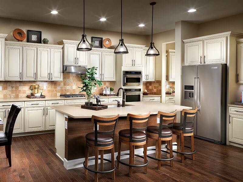 Kitchen with white cabinets, hardwood floors and leather barstools