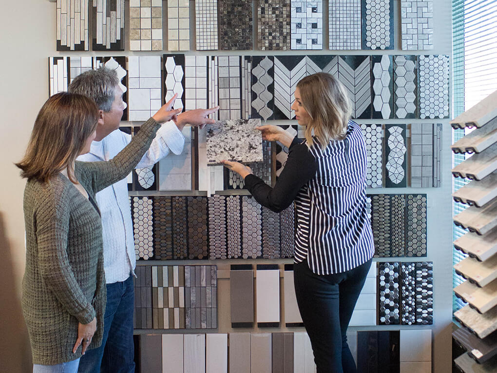 Couple looking at tile samples with a salesperson