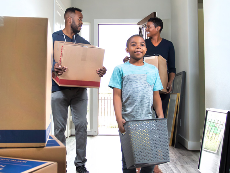 Family carrying moving boxes